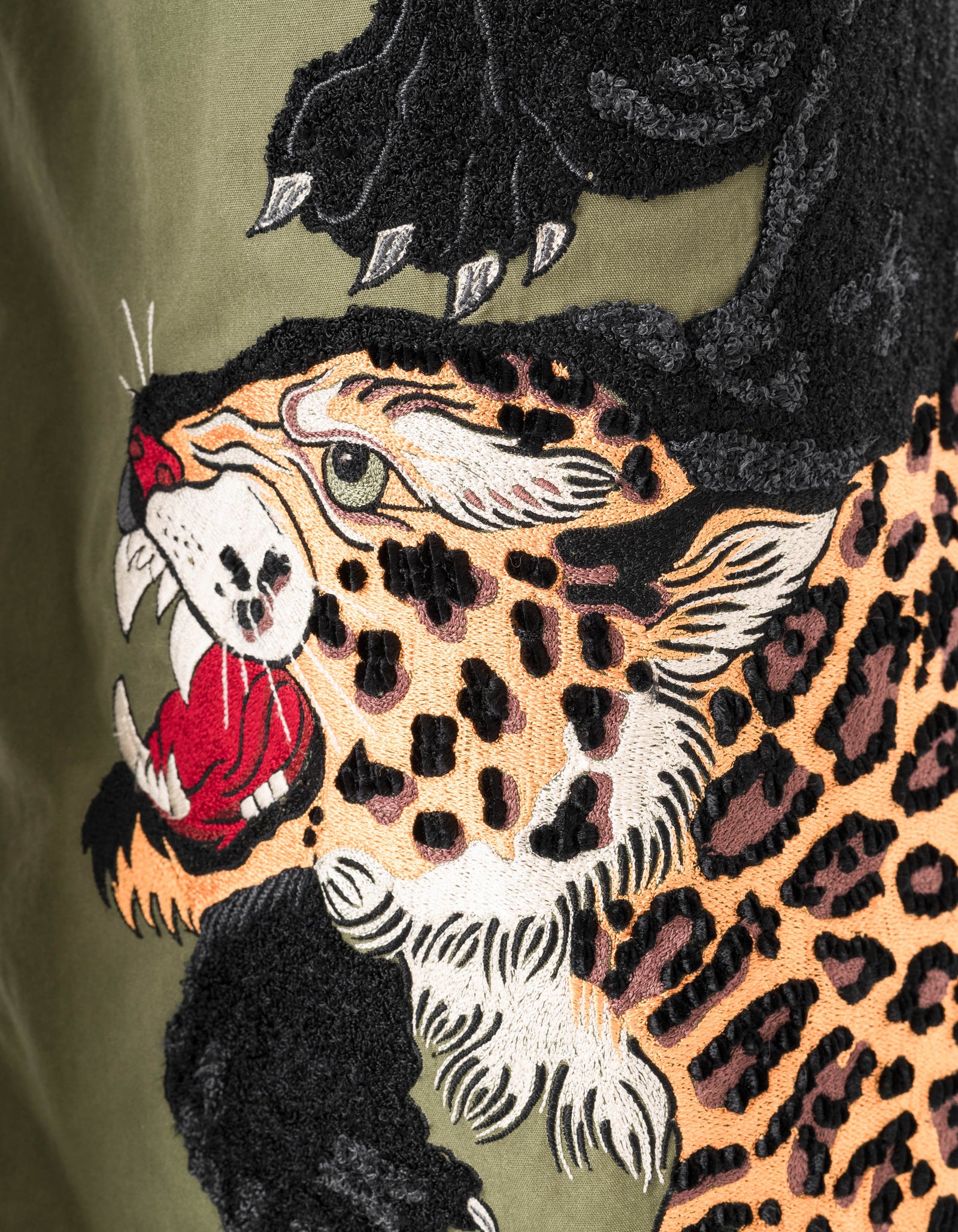 Embroidered design of a panther with a leopard on a green background