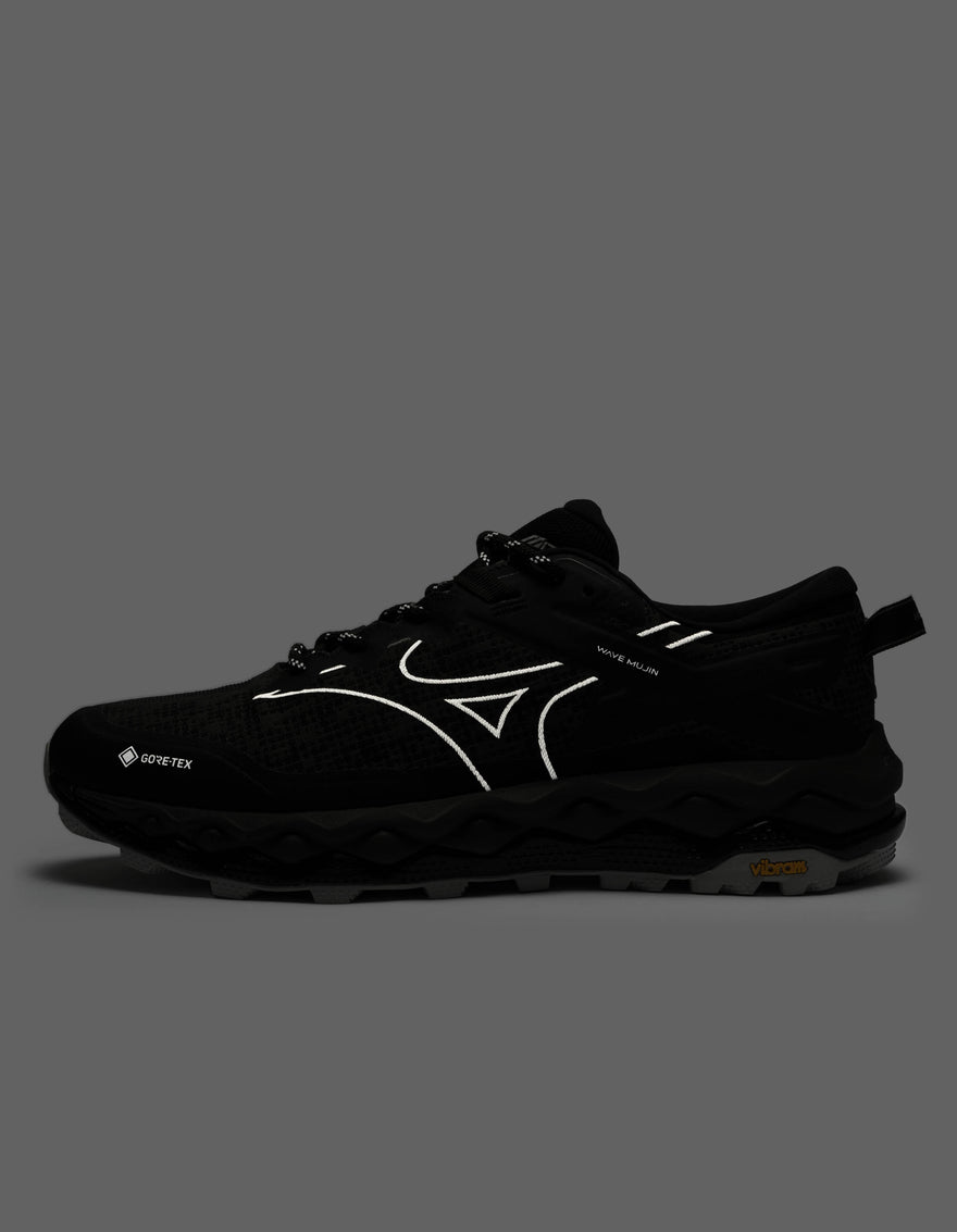 Black running shoe with white accents on a dark gray background