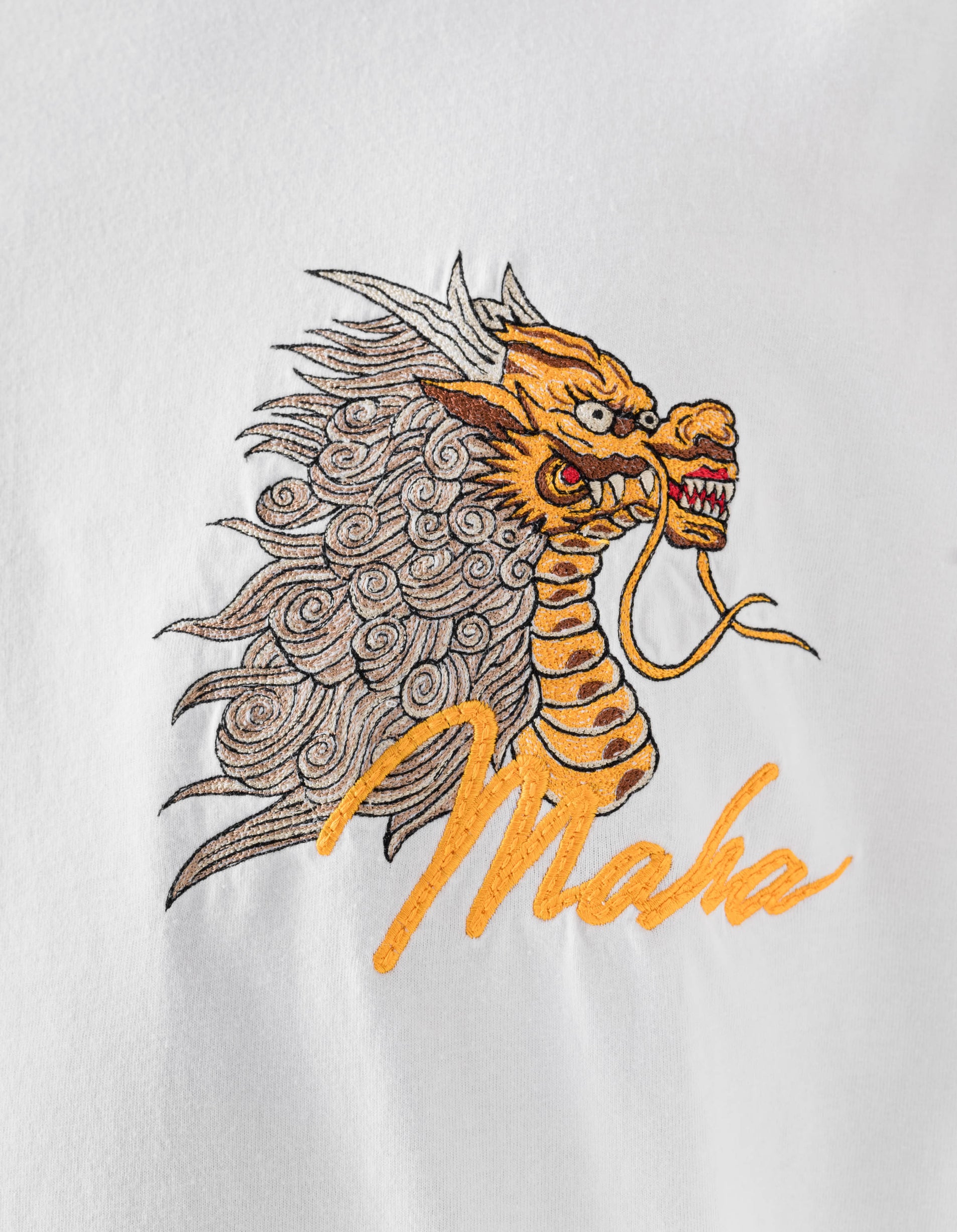 Embroidered dragon design on a white background with 'Maha' text.
