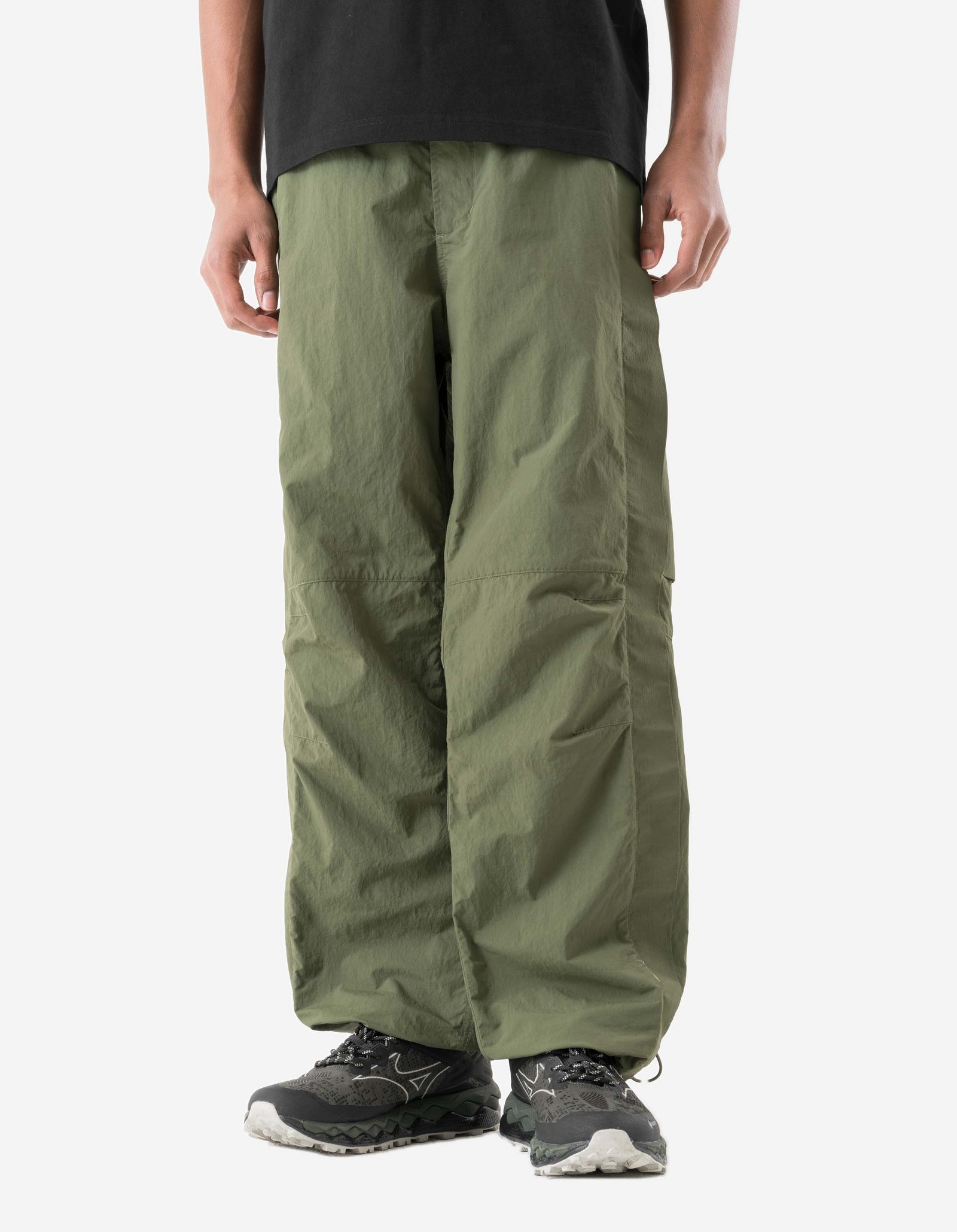 Person wearing olive green pants on a white background