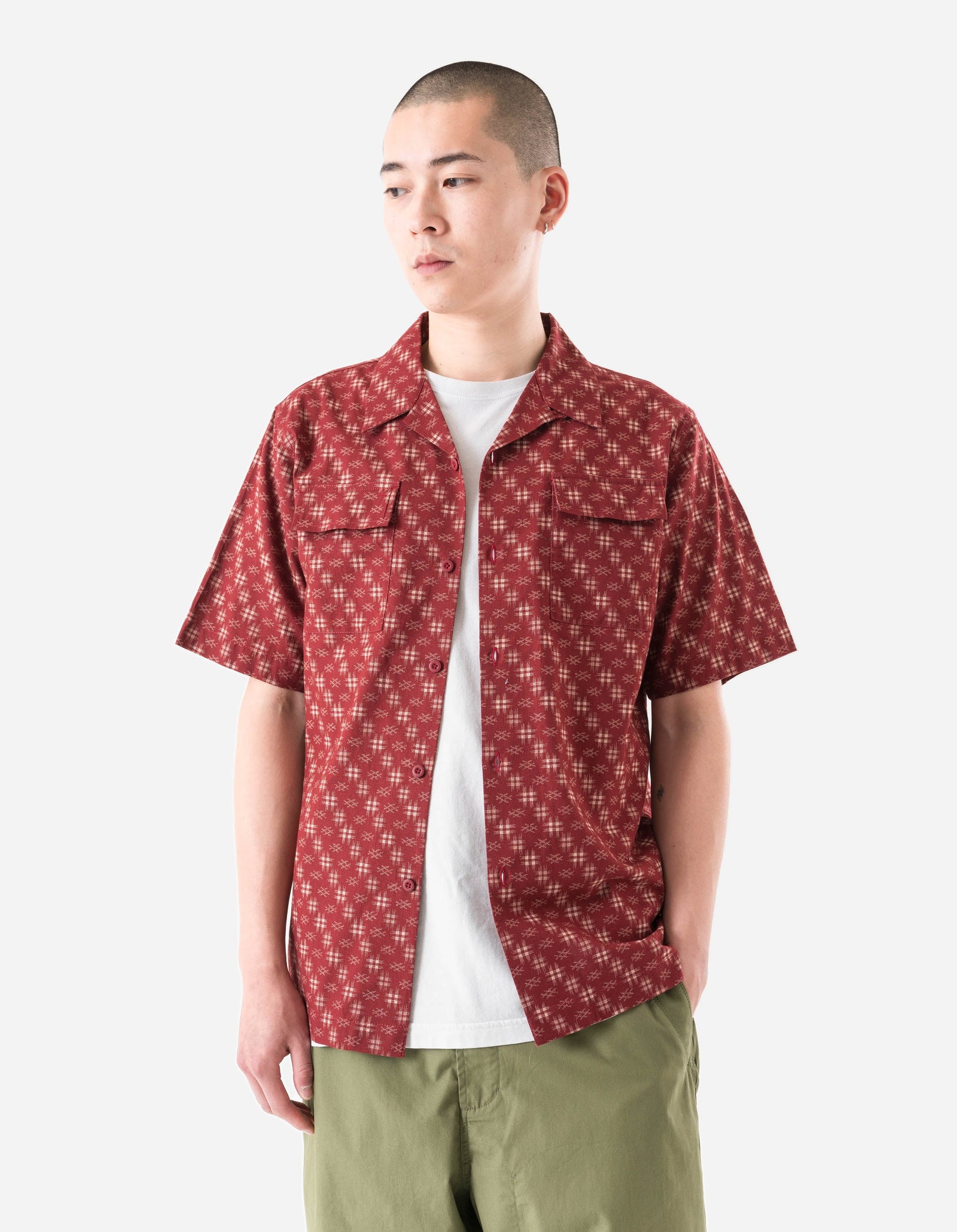 Person wearing a red patterned shirt over a white t-shirt on a white background